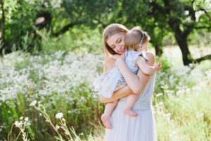 Young mother playing with her little daughter on the nature, motherhood, tenderness, childhood, tenderness, lifestyle